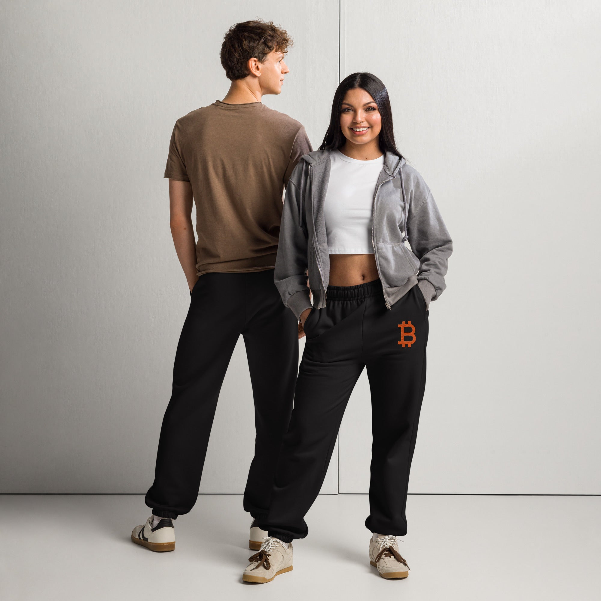 two people wearing Unisex Bitcoin sweatpants relaxed fit with Orange B logo by SVRN_T